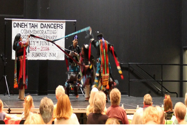Members of the Dineh'Tah Dancers perform a ribbon dance while director Shawn Price, right, drums and sings.