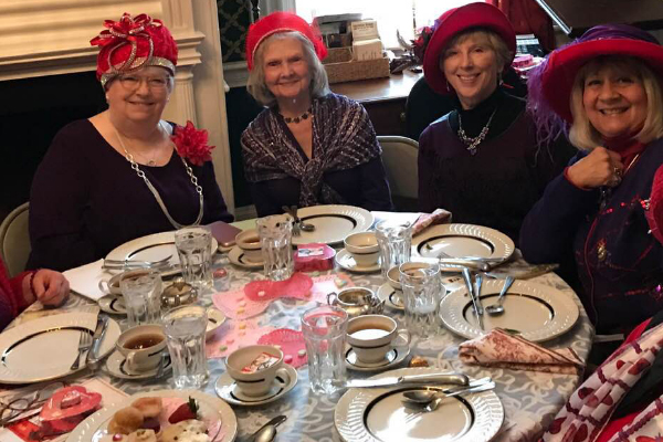 2019 Valentine's Tea - women wearing red hats sitting at a table